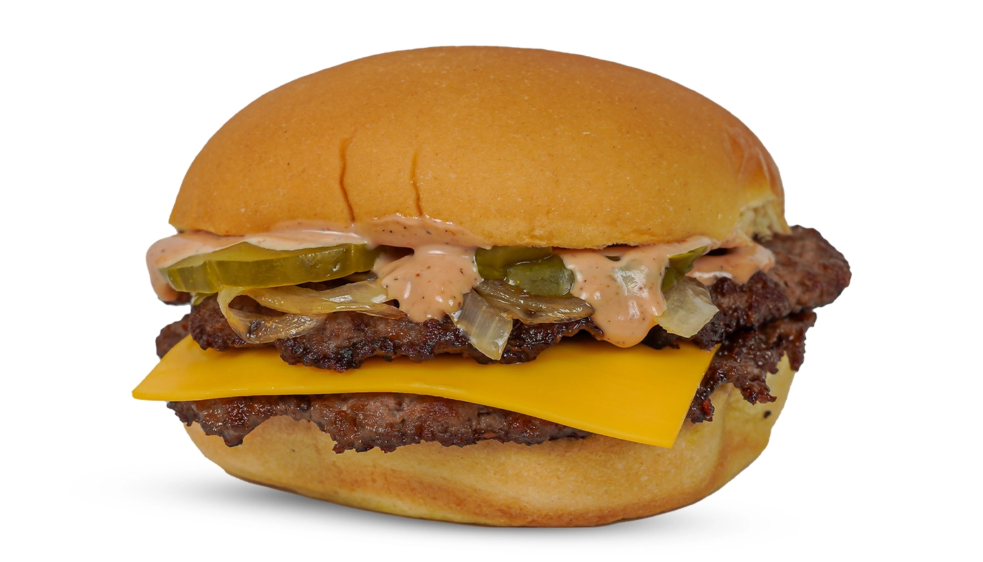 Double-patty cheeseburger with cheddar, pickles, onions, and creamy sauce on a toasted bun.